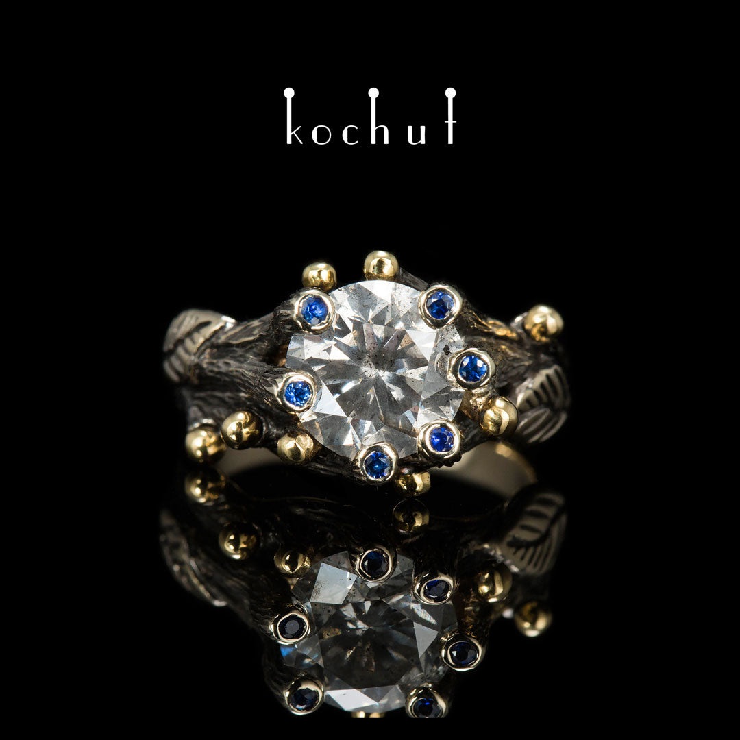 Triumph des Lebens — Verlobungsring aus 18 Karat Weißgold und 14 Karat Gelbgold mit Diamanten und Saphiren, überzogen mit schwarzem Rhodium
