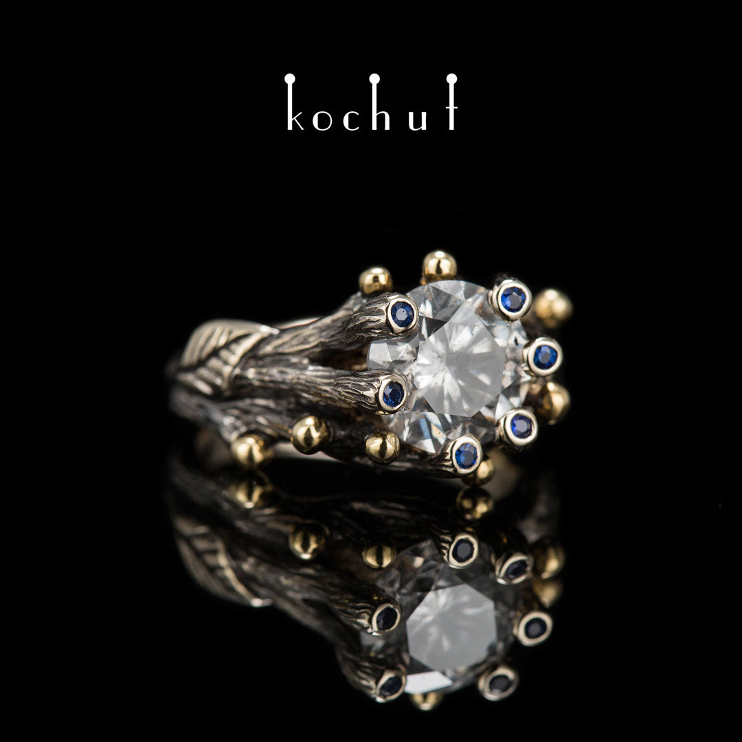 Triumph des Lebens — Verlobungsring aus 18 Karat Weißgold und 14 Karat Gelbgold mit Diamanten und Saphiren, überzogen mit schwarzem Rhodium