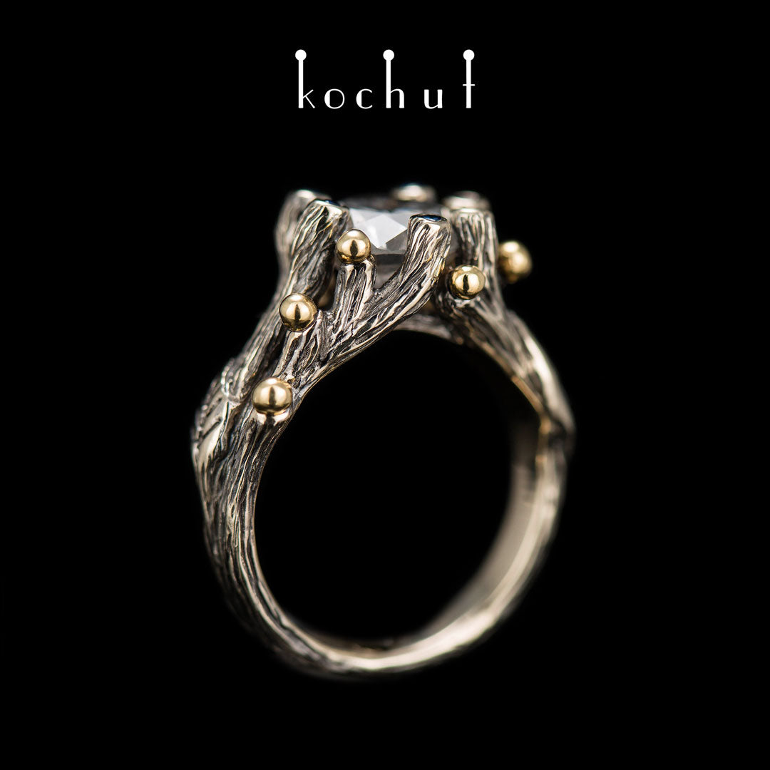 Triumph des Lebens — Verlobungsring aus 18 Karat Weißgold und 14 Karat Gelbgold mit Diamanten und Saphiren, überzogen mit schwarzem Rhodium