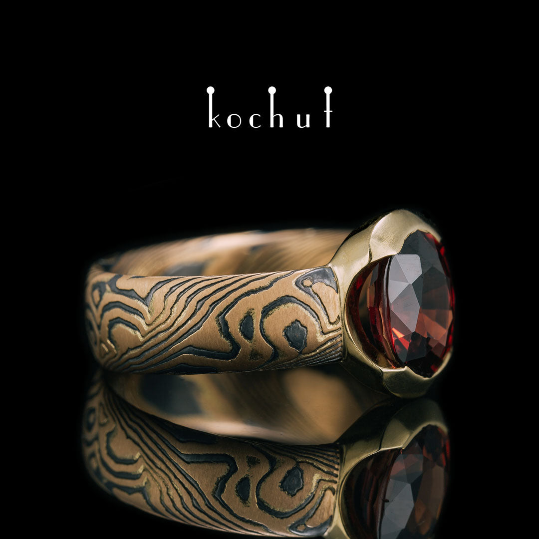 Sophora — Ring aus Rotgold, Gelbgold, graviertem und oxidiertem Silber mit Granat