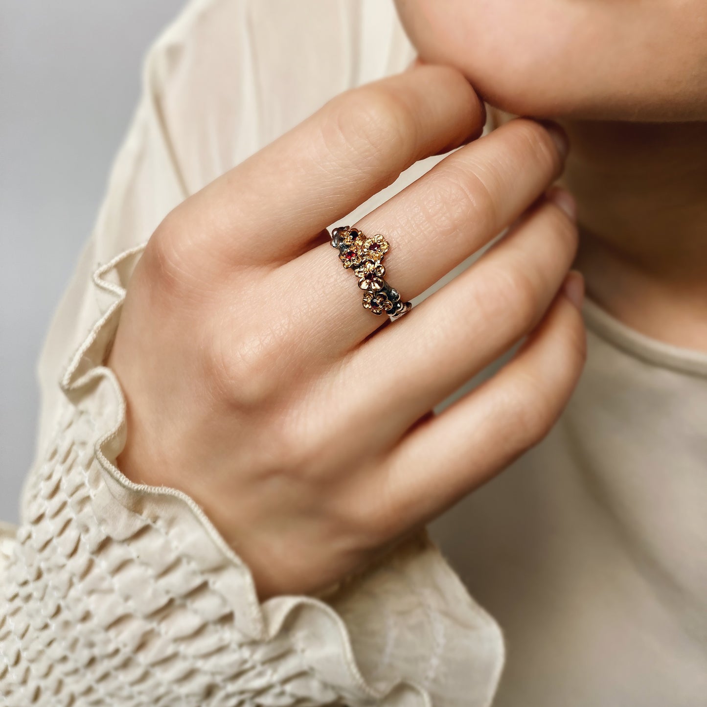 Blumenkrone — Ring aus oxidiertem Silber mit Vergoldung und Rubinen