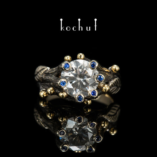 Triumph des Lebens — Verlobungsring aus 18 Karat Weißgold und 14 Karat Gelbgold mit Diamanten und Saphiren, überzogen mit schwarzem Rhodium