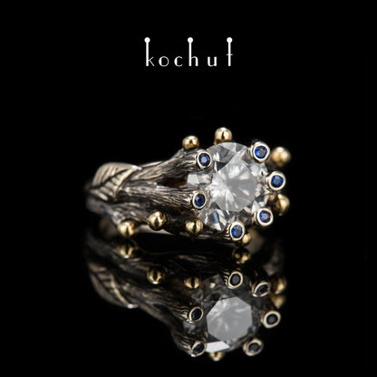 Triumph des Lebens — Verlobungsring aus 18 Karat Weißgold und 14 Karat Gelbgold mit Diamanten und Saphiren, überzogen mit schwarzem Rhodium